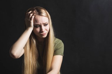 Üzgün genç kadın siyah bir arka planda ağlamaya gidiyor