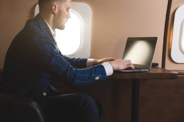 Onun özel jet bir sandalyede otururken bir laptop üzerinde çalışan çekici ve başarılı işadamı.