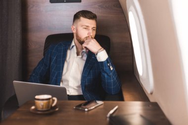 Onun özel jet bir sandalyede otururken bir laptop üzerinde çalışan çekici ve başarılı işadamı.