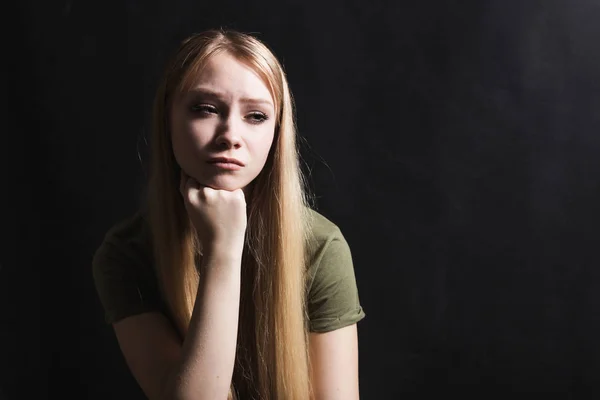 Mujer joven triste va a llorar en un fondo negro —  Fotos de Stock