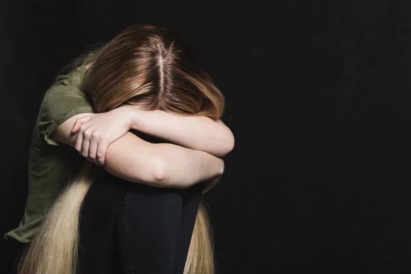 Сумна молода жінка збирається плакати на чорному тлі — стокове фото