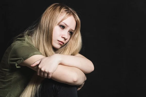 Mujer joven triste va a llorar en un fondo negro — Foto de Stock