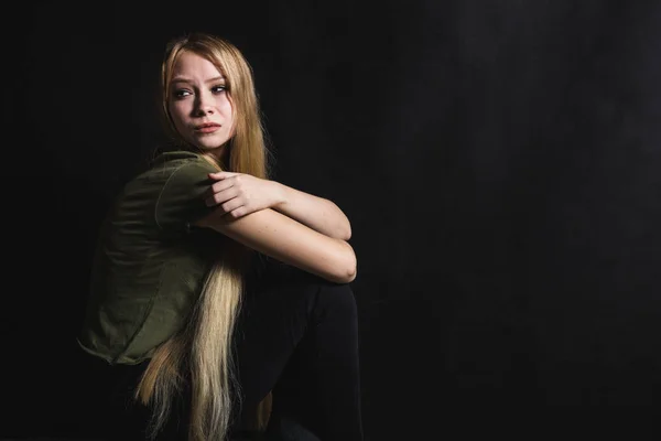 Mujer joven triste va a llorar en un fondo negro — Foto de Stock