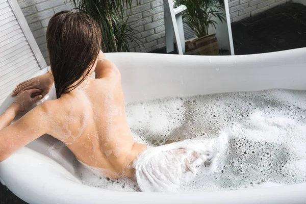 Una giovane ragazza attraente si rilassa in bagno e riposa sullo sfondo di un bellissimo interno leggero. Trattamenti Spa per la bellezza e la salute con la cura della pelle — Foto Stock