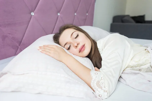 Mooie jonge meisje slapen in haar bed in de ochtend. gezondheid en schoonheid — Stockfoto