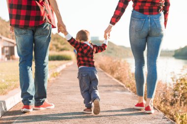 Genç mutlu aile ile çocuk doğada eğleniyor. Anne ile çocuk parkta yürümek