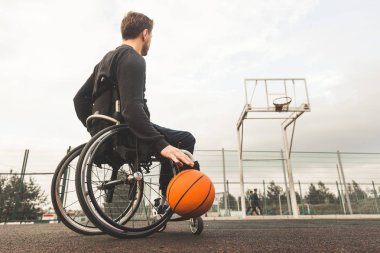 Basketbol oynarken sandalyedeki genç adam.