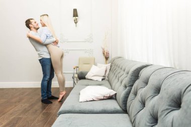 Modern bir iç yüz yüz ile bir oturma odasında güzel genç çift.