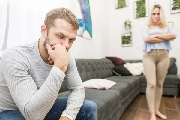 Unhappy young couple quarreling in the living room. — Stock Photo, Image