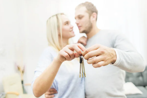 Una bella giovane coppia tiene davanti a loro le chiavi del loro nuovo appartamento . — Foto Stock