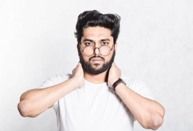 Çekici genç adam boyun el tutar, kas yorgunluk rahatlatmak için çalışır.