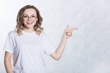 Yakışıklı genç kadın boş kopya uzayda önefinger ile gösterir.