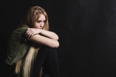 Üzgün genç kadın siyah bir arka planda ağlamaya gidiyor