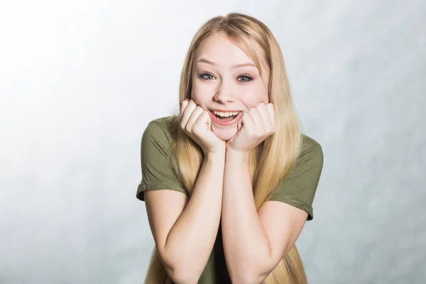 Amazed woman looks with joy and smile, being shocked to hear good news.