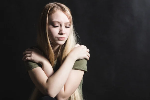 Mujer joven triste va a llorar en un fondo negro — Foto de Stock
