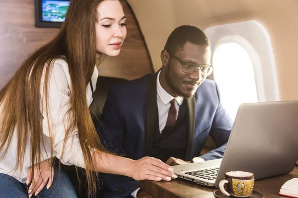Genç başarılı Afrikalı-Amerikan işadamı gözlük ve çekici bir kadın iş arkadaşı Sarışın özel bir Jet. Hizmet ve uçuş birinci sınıf