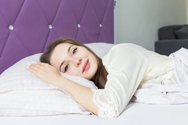 Красива молода дівчина прокидається вранці в її ліжку. здоров'я і краса — стокове фото