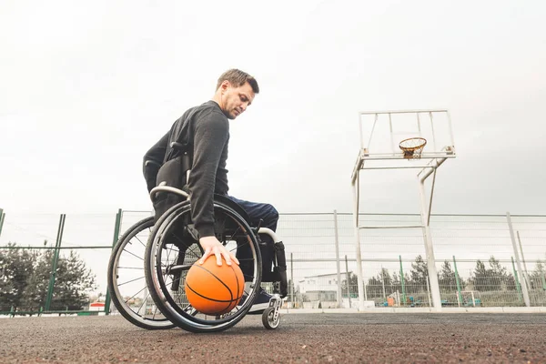 Ung man i rullstol spela basket. — Stockfoto