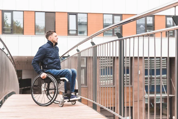 Ο άνθρωπος σε μια αναπηρική καρέκλα Χρησιμοποιήστε μια ράμπα αμαξιδίων. — Φωτογραφία Αρχείου