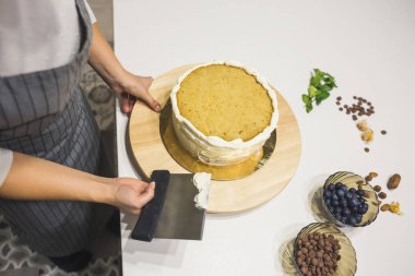 Şekerleme spatulası ile bisküvi pastası üzerine beyaz krema. Ev yapımı hamur işi, kek pişirme....