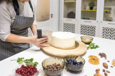 Şekerleme spatulası ile bisküvi pastası üzerine beyaz krema. Ev yapımı hamur işi, kek pişirme....