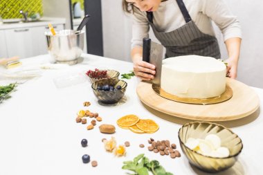 Şekerleme spatulası ile bisküvi pastası üzerine beyaz krema. Ev yapımı hamur işi, kek pişirme....