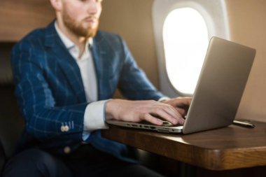 Onun özel jet bir sandalyede otururken bir laptop üzerinde çalışan çekici ve başarılı işadamı.