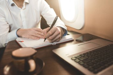 Beyaz gömlekli çekici ve başarılı bir iş adamı özel jetinin koltuğunda oturuyor..