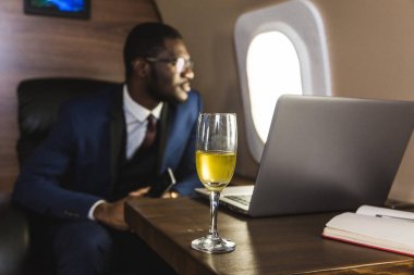 Onun özel jet sandalyede otururken gözlük bir dizüstü bilgisayar üzerinde çalışan çekici ve başarılı Afrikalı Amerikan işadamı.