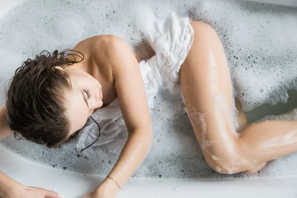 Una giovane ragazza attraente si rilassa in bagno e riposa sullo sfondo di un bellissimo interno leggero. Trattamenti Spa per la bellezza e la salute con la cura della pelle — Foto Stock