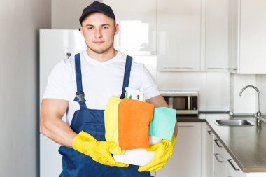 İş sırasında profesyonel ekipmanlarla temizlik hizmeti. Profesyonel mutfak temizliği, kanepe kuru temizleme, pencere ve yer silme. Erkek ve kadın üniformalı, tulumlu ve lastik eldivenli.
