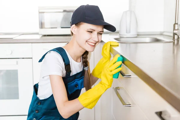 Sprzątanie z profesjonalnym sprzętem podczas pracy. profesjonalne sprzątanie aneksem kuchennym, suszarka do kanapy, mycie okien i podłóg. mężczyźni i kobiety w mundurach, kombinezonach i gumowych rękawiczkach — Zdjęcie stockowe