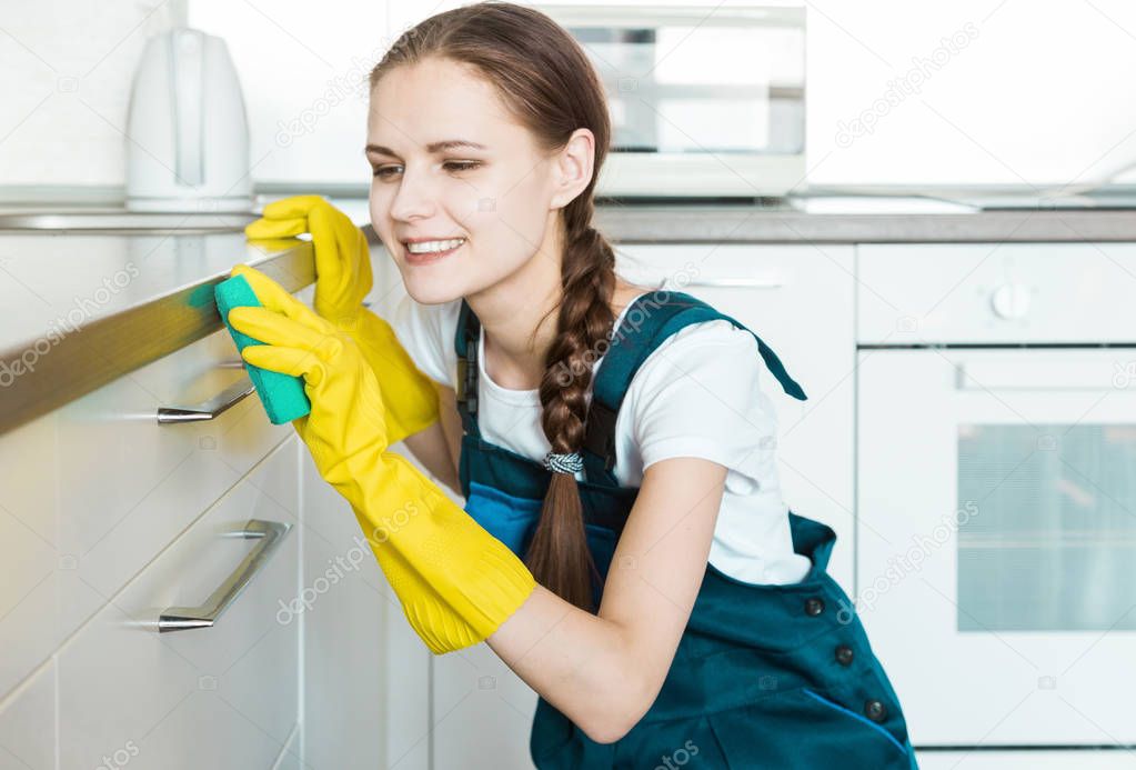 Cleaning service with professional equipment during work. professional kitchenette cleaning, sofa dry cleaning, window and floor washing. man and women in uniform, overalls and rubber gloves