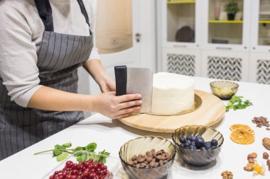 Şekerleme spatulası ile bisküvi pastası üzerine beyaz krema. Ev yapımı hamur işi, kek pişirme....