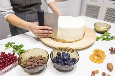 Şekerleme spatulası ile bisküvi pastası üzerine beyaz krema. Ev yapımı hamur işi, kek pişirme....