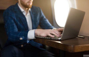 Onun özel jet bir sandalyede otururken bir laptop üzerinde çalışan çekici ve başarılı işadamı.