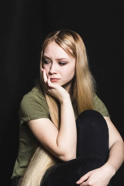 Mujer joven triste va a llorar en un fondo negro — Foto de Stock