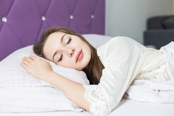 Mooie jonge meisje slapen in haar bed in de ochtend. gezondheid en schoonheid — Stockfoto