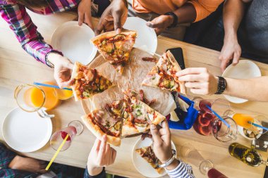 Bir kafede pizza yiyen, kokteyl içen, eğlenen çok kültürlü gençlerden oluşan bir şirket.
