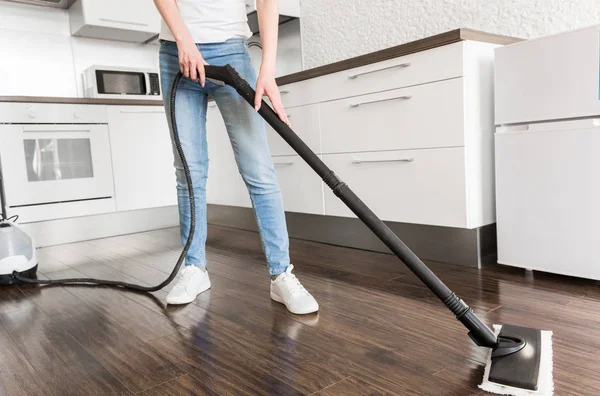 Professional home cleaning service. Woman washes the floor with a steam mop — Stock Photo, Image