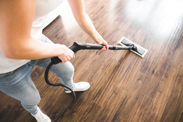 Servicio profesional de limpieza del hogar. Mujer lava el suelo con una fregona de vapor —  Fotos de Stock