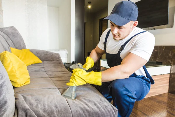 Schoonmaakservice met professionele apparatuur tijdens het werk. professionele kitchenette schoonmaak, sofa stomerij, raam en vloer wassen. mannen en vrouwen in uniform, overall en rubberen handschoenen — Stockfoto