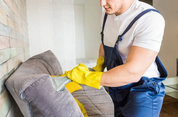 Serviço de limpeza com equipamento profissional durante o trabalho. limpeza kitchenette profissional, sofá limpeza a seco, janela e lavagem de piso. homem e mulher de uniforme, macacão e luvas de borracha — Fotografia de Stock