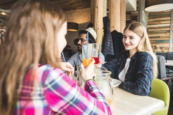 Meet young attractive people in the cafe. Friends chat, have fun, drink cocktails and eat