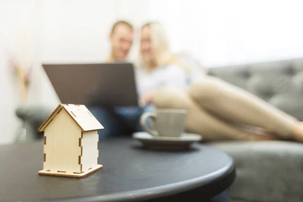 Preciosa pareja joven, utilizando un ordenador portátil y la elección de un nuevo apartamento. Diseño de la casa en primer plano . — Foto de Stock