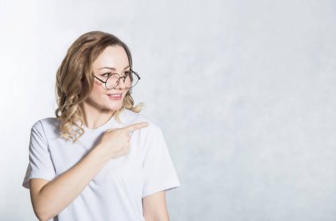 Yakışıklı genç kadın boş kopya uzayda önefinger ile gösterir.