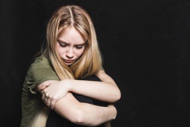 Üzgün genç kadın siyah bir arka planda ağlamaya gidiyor