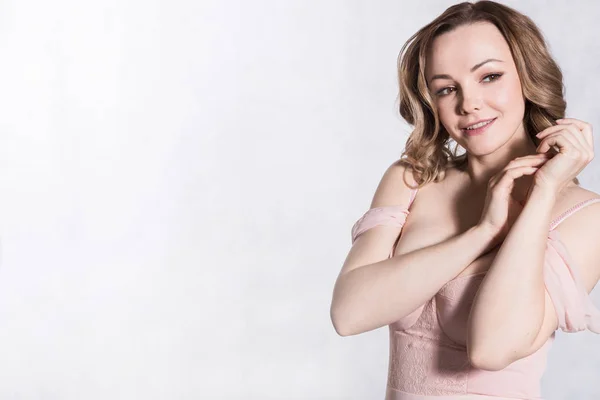 Retrato de hermosa joven elegante mujer en vestido de novia de color rosa pálido con escote grande, sobre un fondo blanco . — Foto de Stock