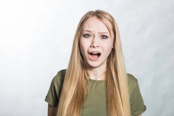 Retrato de mujer joven gritando enojada sobre el fondo gris . —  Fotos de Stock