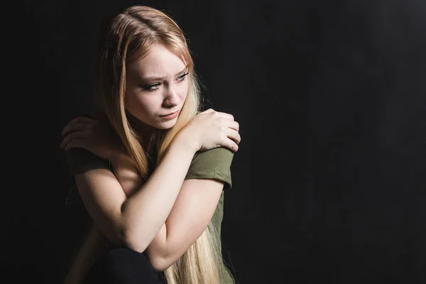 Mujer joven triste va a llorar en un fondo negro — Foto de Stock